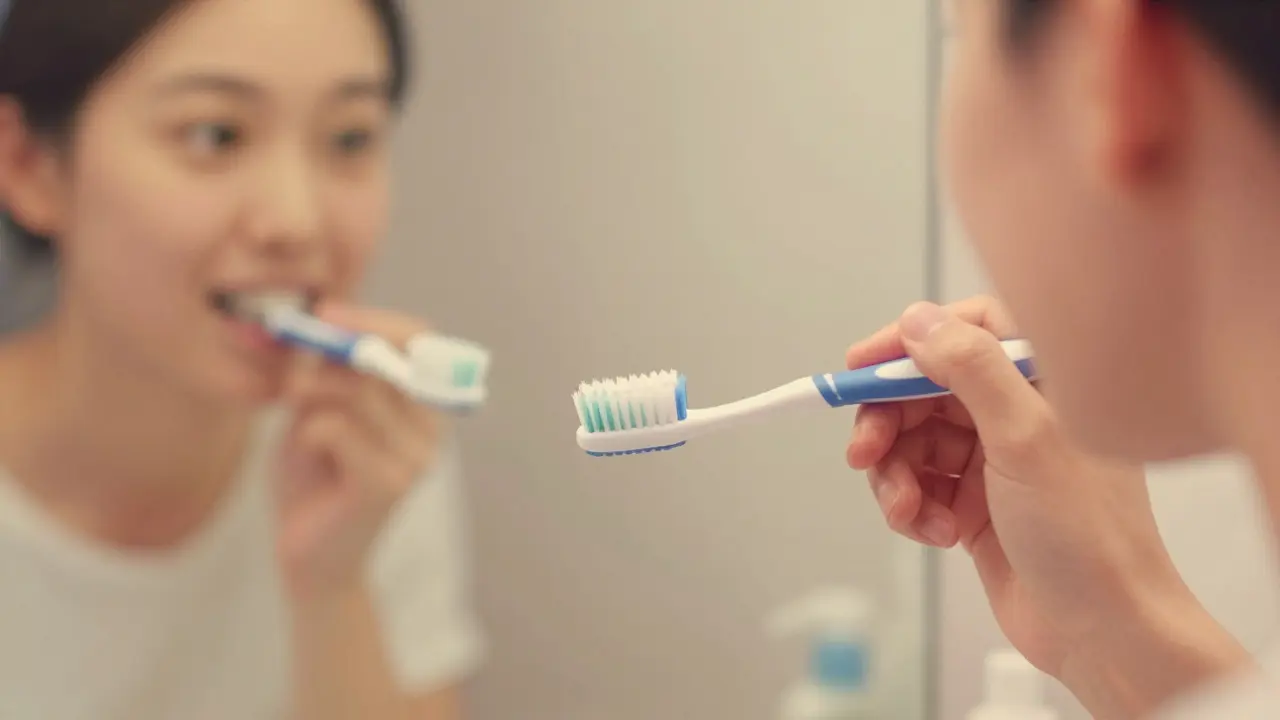 Ruka čistí zuby Curaprox kartáčkem pod úhlem 45 stupňů